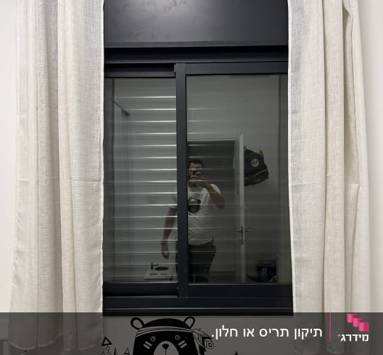 חלון עם תריסים סגורים ומסגרת שחורה